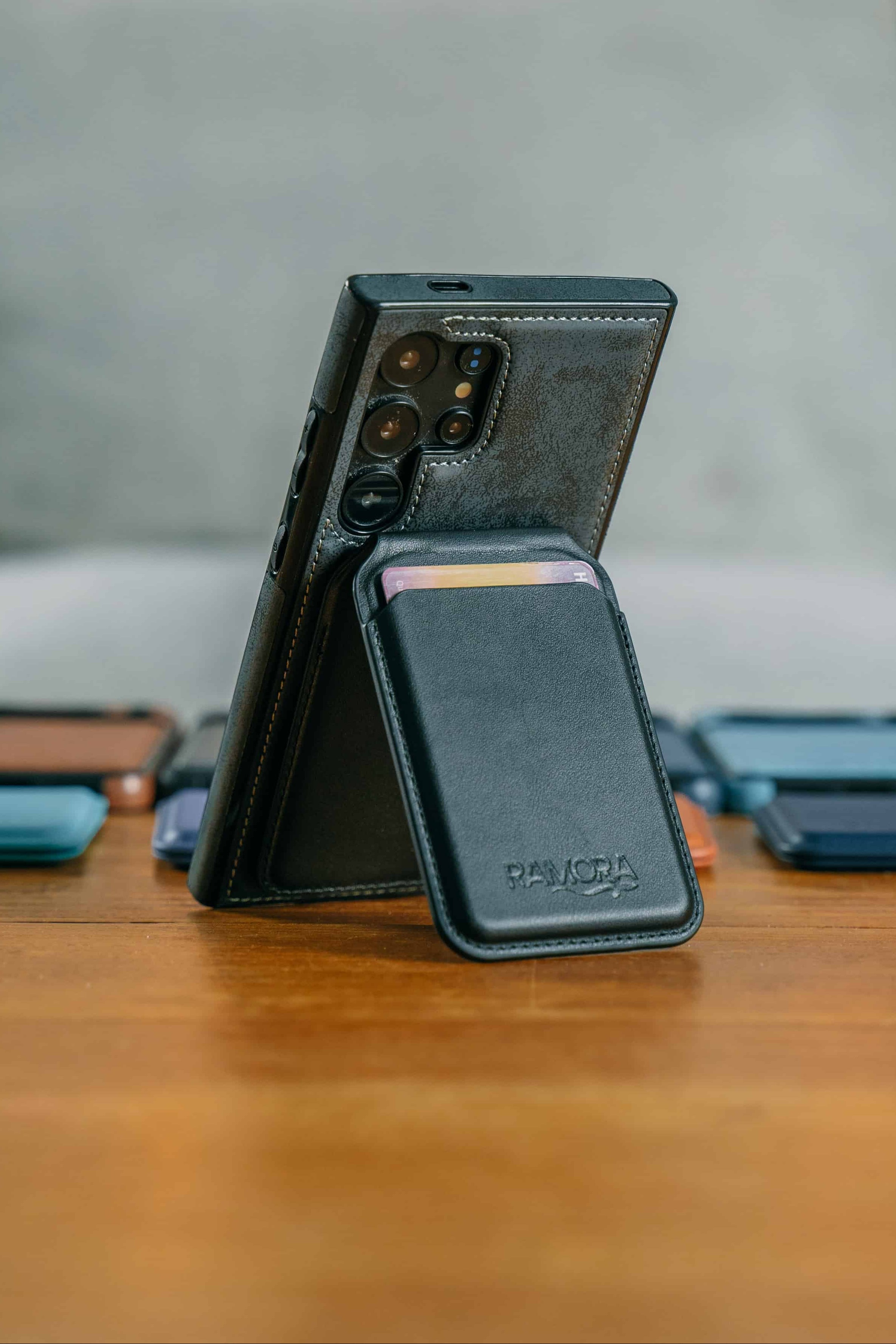 Black phone case with card holder on a wooden table